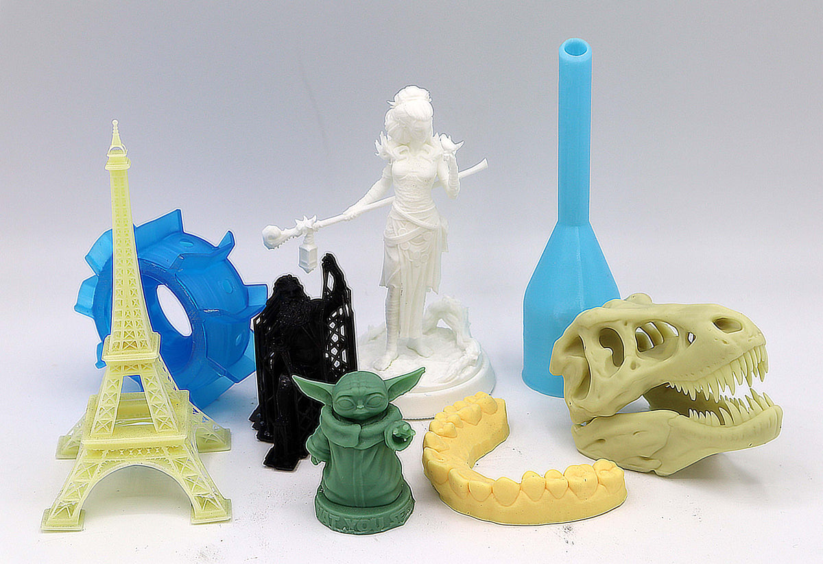 Assorted colorful 3D printed models including an Eiffel Tower, a skull and small figures